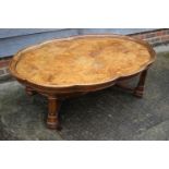 A burr oak shape top parquetry low coffee table, on square mounded supports united by and 'H'