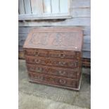 An 18th century and later carved oak fall front bureau, inscribed Ben Johnson, fitted four long
