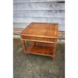 A walnut and banded two-tier lamp table, fitted one drawer, on square taper supports, 26" square x