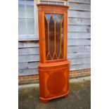 A yew wood bowfront corner display cabinet enclosed lattice glazed door, over figured door, on