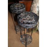 A pair of cast iron circular topped two-tier garden tables, 11 1/2" dia x 29" high (damages)