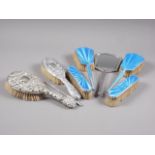 A silver and enamel dressing table set and two embossed silver backed brushes