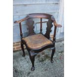 A Georgian mahogany corner elbow chair with scroll splats and drop-in leather seat, on shell