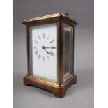 A brass cased carriage clock with white enamel dial and Roman numerals, 4 3/4" high
