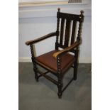 A carved oak elbow chair with drop-in seat, on turned and stretchered supports
