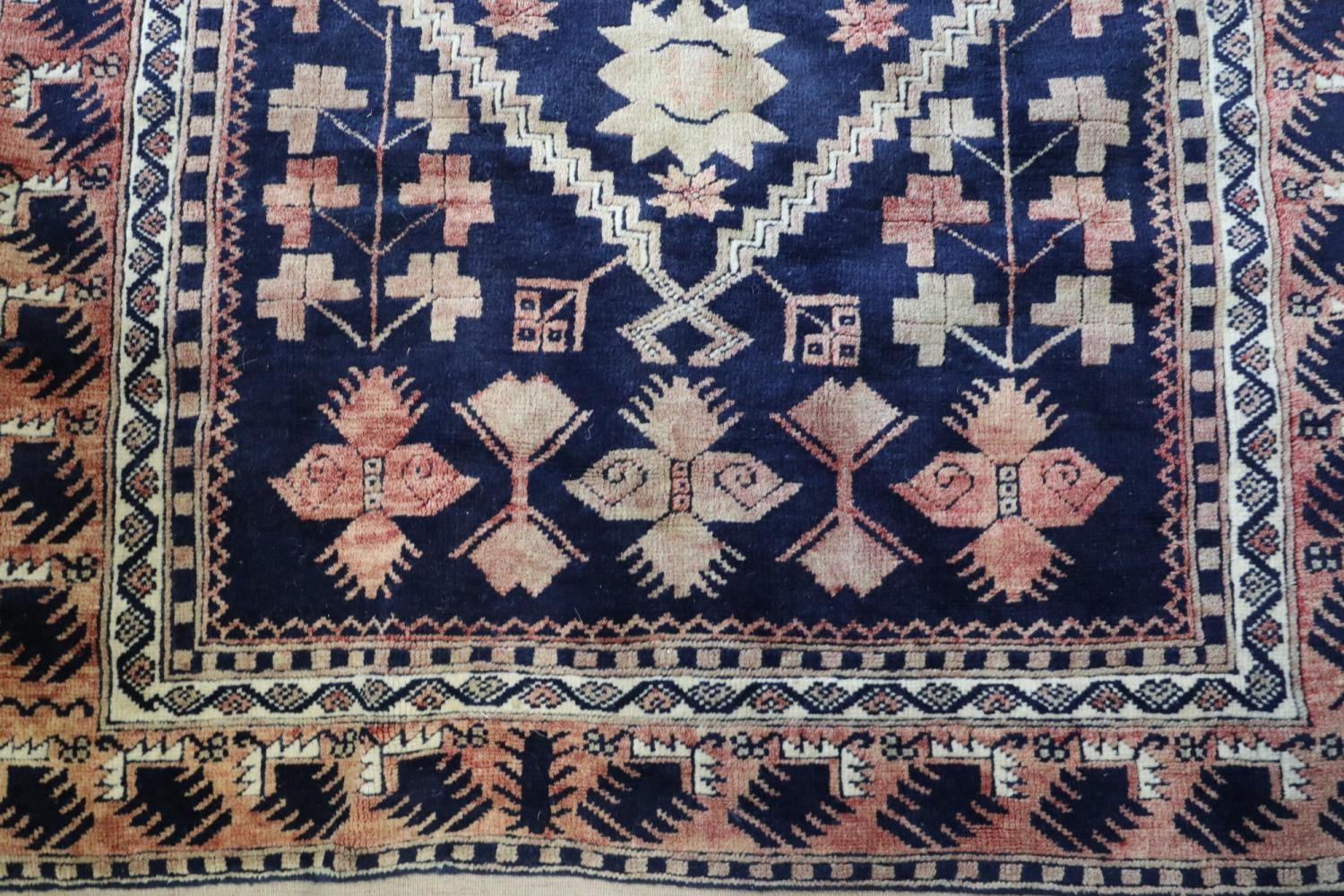 A Caucasian tribal rug with stylised floral centre on a blue ground and multi-bordered in shades - Image 2 of 3