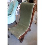A late 19th century walnut showframe low seat nursing chair, on scroll supports