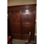 An  18th century oak hall cupboard, fitted two carved doors over two drawers, on ball supports,