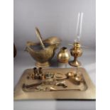 An assortment of brassware including a tray, 24 1/4" wide, a coal helmet, an oil lamp, a Jersey jug,