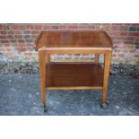 A 1950s polished as walnut two-tier tea trolley, on wheeled supports, 26" wide x 17" deep x 28 1/
