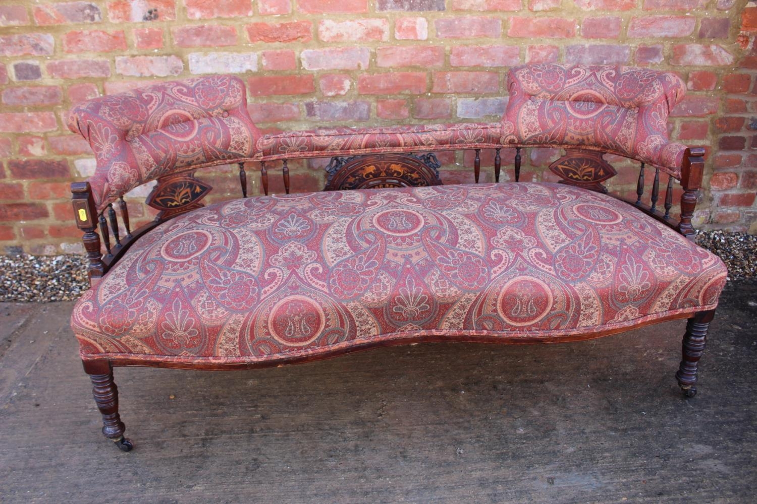 An early 20th century rosewood and line inlaid "conversation" settee with splat and spindle padded
