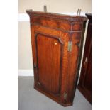 A 19th century oak quarter cut oak and mahogany banded corner hanging cupboard enclosed one door,