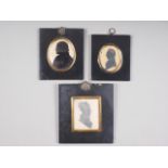 A 19th century portrait miniature silhouette of a man and two similar portraits, in ebonised frames