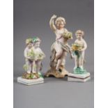 A Derby porcelain cherub with basket of flowers, 4" high, two similar figures, 4 1/2" high and 4"