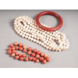 A freshwater pearl necklace, 31 1/2" long, a Chinese red lacquered bangle and a coral type beaded