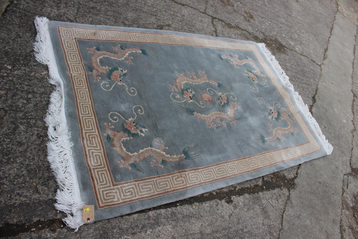 A Chinese contour pile rug with dragon design on a grey ground, 75" x 49"