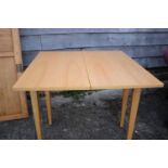 A beech fold over top dining table, on square taper supports, 32" wide x 16" deep x 29 1/2" high