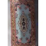A Persian rug of traditional design with central medallion on a turquoise blue ground and bordered