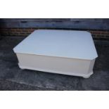 A white painted octagonal top coffee table, 48" wide