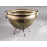 A hammered brass jardiniere with ring handles, on a brass stand with paw supports, 15 3/4" dia x 14"