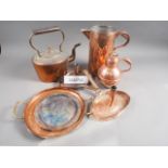 An assortment of copperware, including a kettle, a Jersey jug, two chamber sticks, trays and other