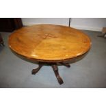 A late Victorian walnut and scroll paterae inlaid oval loo table, on turned column and splay