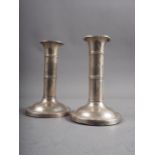 A pair of silver candlesticks with banded decoration, 5" high (misshapen)