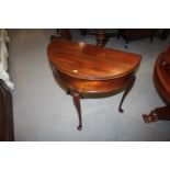 A mahogany semicircular fold-over top tea table, on cabriole supports and pad feet, 27" wide x 13