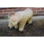 An early 20th century straw filled "push along" bear with iron wheels, 24" long (well played with)