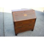 An Edwardian mahogany and inlaid bureau with fitted interior over three drawers, on bracket feet,