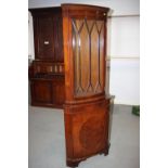 A mahogany and banded bowfront corner display cabinet, the upper section enclosed lattice glazed