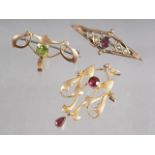 A 9ct gold and garnet Art Nouveau pendant, a similar 9ct gold and peridot brooch, and a 9ct gold,