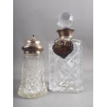 A silver collared decanter with a silver whisky label and a silver topped sugar shaker
