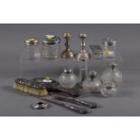 A collection of nine silver mounted toilet jars, various, a pair of filled silver candlesticks, a