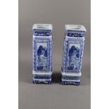 A pair of Chinese blue and white square landscape decorated jars with seal marks to base, on stands,