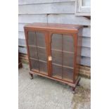 A 1930s walnut display cabinet/bookcase enclosed two shape top lattice glazed doors, on cabriole