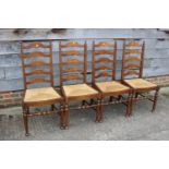 A set of four ladder back dining chairs with rush envelope seats, on turned and stretchered supports