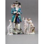 A Sitzendorf porcelain figure of a flower seller, 9 3/4" high (damages), two Continental porcelain