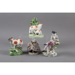 A Continental seated figure with a dog, 6 1/2" high, another similar figure, a Staffordshire model