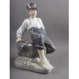 A circa 1960s Royal Copenhagen figure of a shepherd boy sitting on a rock, 12 1/2" high