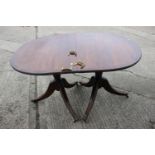 A mahogany and banded double pedestal dining table with two extra leaves, on turned columns and