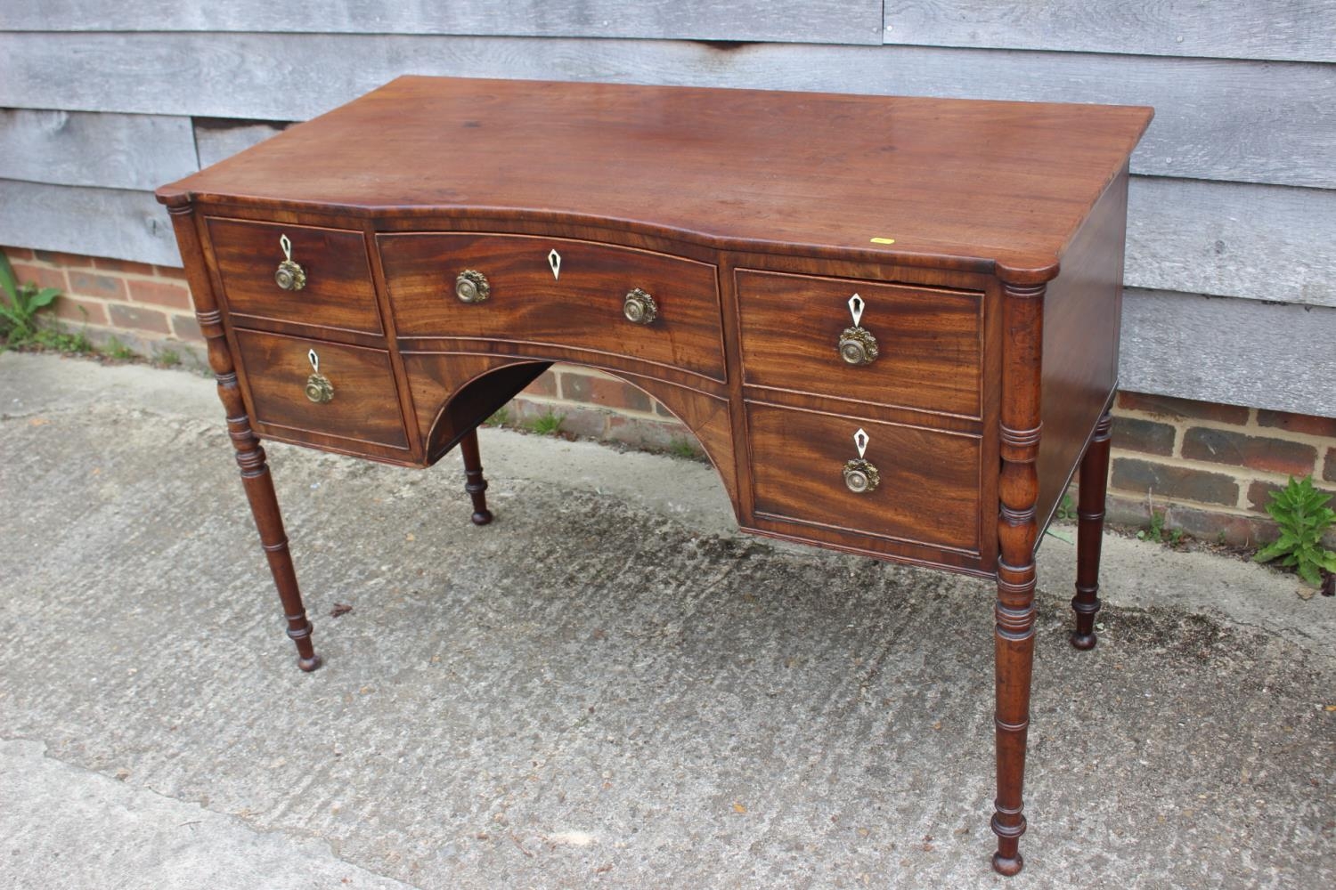 A George III mahogany inverse breakfront sideboard/dressing table, fitted five drawers with brass