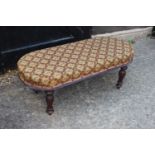 A Victorian mahogany oval top stool with floral tapestry seat on carved supports, 35" wide x 15"