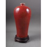 A Chinese sang de boeuf baluster vase, 9" high, on associated hardwood stand