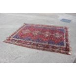 A Caucasian wool pile rug with geometric designs and four central medallions in shades of natural,