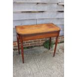 An early 19th century mahogany rosewood banded and box line inlaid fold-over top card table, on