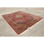 A Belgian rug of traditional Persian design with central medallion on a red ground, 140" x 99"
