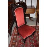 A late 19th century carved showframe nursing chair, upholstered in a rust velour, on cabriole