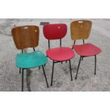 Three 1960s painted padded shaped back and seat dining chairs, on metal supports