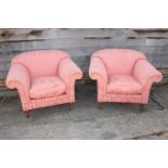 A pair of deep arm chairs with loose seat cushions, on turned supports